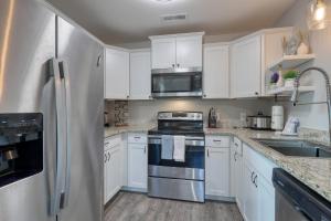 a kitchen with white cabinets and a stainless steel refrigerator at 1408 Perrin Dr, Unit A - Ocean Walk Sleeps 8 in Myrtle Beach