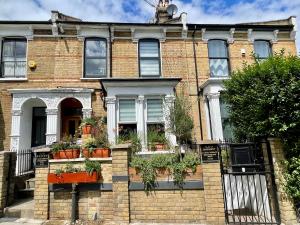 a brick house with potted plants in front of it at Ensuite Room with Jacuzzi in London