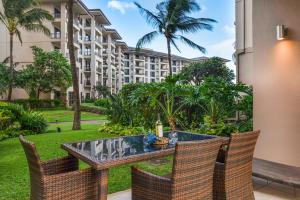 a patio with a table and chairs and a building at KBM Resorts: Honua Kai HKH-114 1Bd w Rental Car in Kaanapali