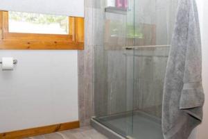 La salle de bains est pourvue d'une douche en verre et d'une fenêtre. dans l'établissement Lake Moraine Home #6 Near Colgate University, à Hamilton