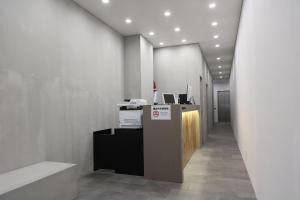 an office lobby with a desk with a computer on it at OHWA hostel minowa station in Tokyo