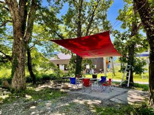 a red tent hanging from a tree in a yard at Pension Eastmountain Hakuba in Hakuba