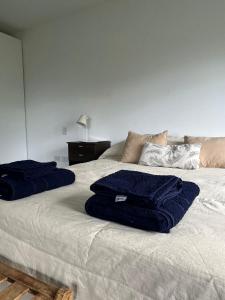 Una cama con dos toallas azules encima. en Las Lavandas 2 en Ushuaia