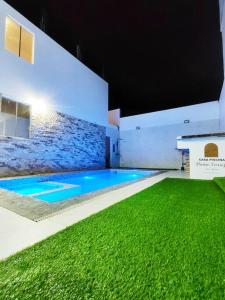 a swimming pool with green grass in a building at Casa Privada de Estreno con Piscina en Ica in Ica