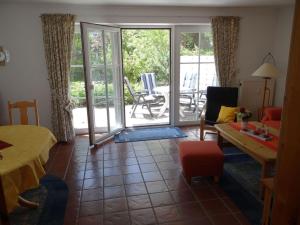 a living room with a door open to a patio at Achtern-Diek-3 in Brösum