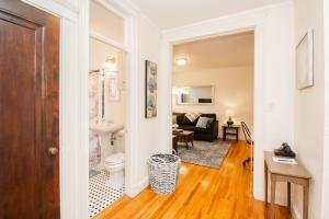 a bathroom with a toilet and a living room at Sun-filled 1bed, Corner Unit W Pool In Com Ave in Boston