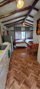 eine Küche mit 2 Betten und Holzboden in der Unterkunft Eco Lodge Cabañas con Piscina in Urubamba