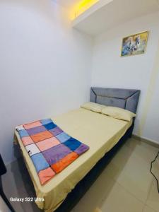 a bed with a colorful quilt on it in a room at Tide Private Couples Room 7 min from Mall of Emirates in Dubai