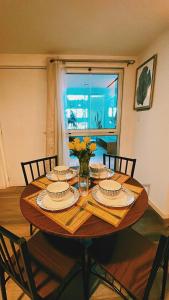 un tavolo da pranzo con piatti e un vaso di fiori di Estudio Luxury zona 13 Aeropuerto a Guatemala