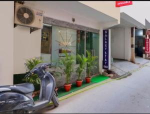 a scooter parked in front of a building with plants at Hotel Galaxy Stay B&B in New Delhi