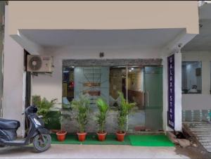 una moto estacionada frente a un edificio con plantas en Hotel Galaxy Stay B&B en Nueva Delhi