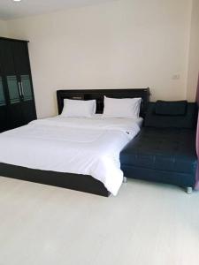 um quarto com uma cama e um sofá azul em The Beach Bangsaen Condo 327/30 em Ban Bang Saen (1)
