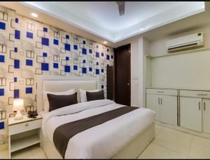 a bedroom with a large bed with blue squares on the wall at Hotel Galaxy Stay B&B in New Delhi