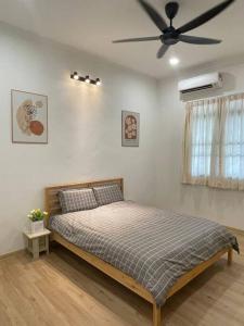 Schlafzimmer mit einem Bett und einem Deckenventilator in der Unterkunft Cozy 2StoreyHome 5Room11Pax@ChaiLengPark in Perai