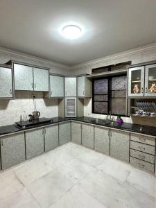 uma grande cozinha com pisos em azulejos brancos e armários em Cozy 2StoreyHome 5Room11Pax@ChaiLengPark em Perai