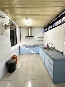 uma grande cozinha com armários azuis e um lavatório em Cozy 2StoreyHome 5Room11Pax@ChaiLengPark em Perai
