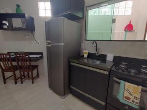 een keuken met een roestvrijstalen koelkast en een fornuis bij Solares le Bien apartamento proxímo a praia in Búzios +18 foto's