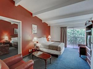 a hotel room with two beds and a balcony at Scottish Inn Whippany in Whippany