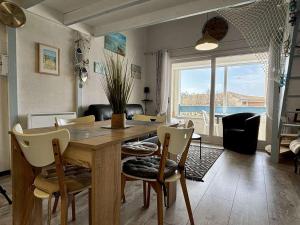 uma sala de jantar com uma mesa e cadeiras com vista para o oceano em Appartement Saint-Pierre-d'Oléron, 2 pièces, 4 personnes - FR-1-246A-294 em Saint-Pierre-dʼOléron
