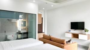 a bedroom with two beds and a television on the wall at Sea Flower Homestay in Quy Nhon