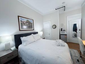 a bedroom with a large white bed and a desk at Sunny Private Room,longwood, 10min Walk To Fenway in Brookline