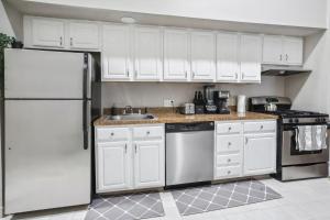 a kitchen with white cabinets and a stainless steel refrigerator at Crown New Haven Hotel at Yale in New Haven