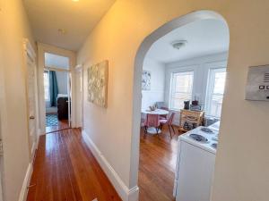 an archway in a room with a kitchen and a table at Sunny,spacious, Sleeps 4, Steps To Mbta,hospitals in Brookline