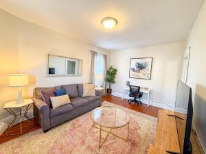 a living room with a couch and a table at Sunny,spacious, Sleeps 4, Steps To Mbta,hospitals in Brookline