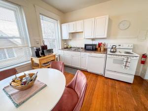 a kitchen with a table and a white stove top oven at Sunny,spacious, Sleeps 4, Steps To Mbta,hospitals in Brookline