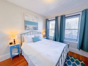 a bedroom with a large bed and two windows at Sunny,spacious, Sleeps 4, Steps To Mbta,hospitals in Brookline