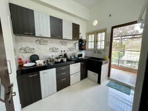 a kitchen with black and white cabinets and a window at Beautiful 2bhk near Begumpet in Hyderabad