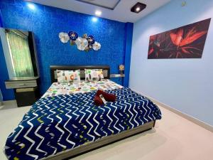 a bedroom with a bed with a blue wall at Beautiful 2bhk near Begumpet in Hyderabad