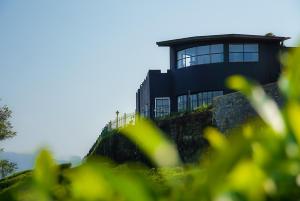a black house on top of a hill at Dover Cottage in Nuwara Eliya