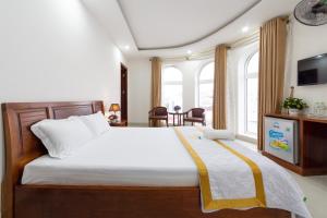 um quarto com uma cama grande e uma mesa em Diamond Sea Hotel em Vung Tau