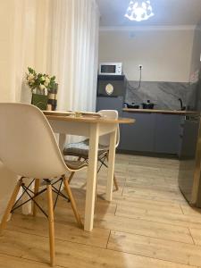 a kitchen with a table and chairs in a room at 1кмн Квартира по проспекту Республика 30 in Astana +3 photos