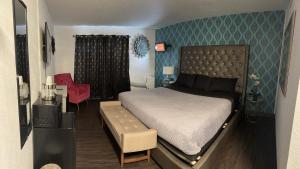 - une chambre avec un lit et une chaise dans l'établissement The Village Inn Hotel, à Milwaukee