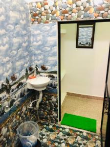 baño con lavabo y una pintura de nubes en Blue Heaven Home Stay, en Khajurāho