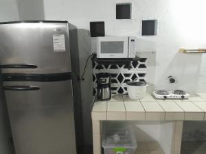 eine kleine Küche mit einem Kühlschrank und einer Mikrowelle in der Unterkunft Sarita's House in Esterillos Este