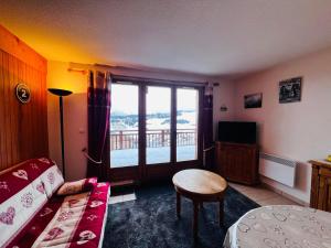 ein Wohnzimmer mit einem Sofa, einem Tisch und einem Fenster in der Unterkunft Appartement Les Saisies, 2 pièces, 6 personnes - FR-1-293-399 in Hauteluce