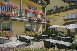 un restaurant avec des tables et des chaises en face d'un bâtiment dans l'établissement Best Western Plus Au cheval Blanc à Mulhouse, à Baldersheim