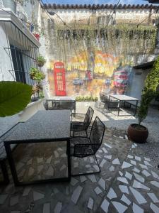 a patio with a table and chairs and a red phone booth at The Hostal Pub Antigua Guatemala in Antigua Guatemala