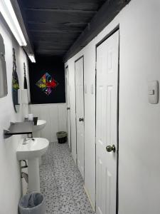 a white bathroom with a sink and a toilet at The Hostal Pub Antigua Guatemala in Antigua Guatemala