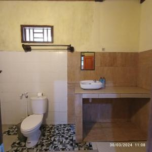a bathroom with a toilet and a sink at Tangga Bungalows in Gili Islands