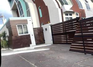 a wooden fence in front of a house at LIGUANEA -ONE BEDROOM OASIS near US EMBASSY in Barbican
