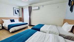 een hotelkamer met 2 bedden en een raam bij Yue Xi B&B in Jinhu