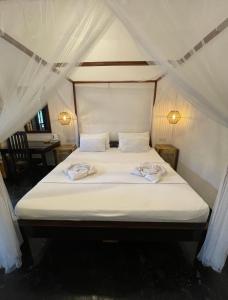 a bed in a tent with two towels on it at Agra Arugambay in Arugam Bay