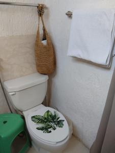 La salle de bains est pourvue de toilettes, d'une serviette et d'un panier. dans l'établissement Beach Cat 3, à Cancún