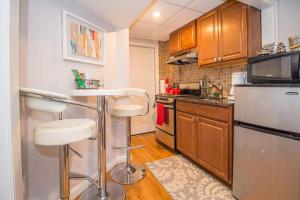 a kitchen with a bar stool and a microwave at Renovated Studio At A 10min Walk To Fenway, T in Brookline
