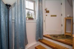 a hallway with blue curtains next to a window at Renovated Studio At A 10min Walk To Fenway, T in Brookline