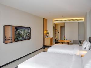 Habitación de hotel con 2 camas y TV de pantalla plana. en CitiGo HOTEL - 越南平阳新渊欢阁酒店 